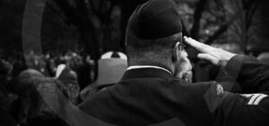 A Canadian military member saluting. Image is black and white